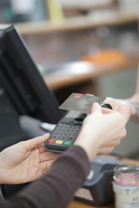 A person purchasing something with their credit card. 
